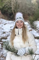 a lady in a white down coat and a white knit hat